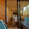 Interno di una casa con tavolo, sedie e accesso a un patio esterno.