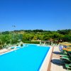 Piscina blu circondata da lettini e ombrelloni.