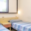 Camera con due letti singoli e luci da parete.