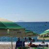 Spiaggia con ombrelloni e persone vicine al mare.