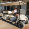 Persona seduta su una golf car bianca parcheggiata.
