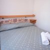 Camera con letto matrimoniale, cuscini e asciugamani bianchi.