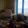 Stanza con letto colorato, finestra vista mare e vassoi per caffè.