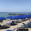 Spiaggia con ombrelloni blu e lettini.