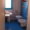 Bagno con sanitari e piastrelle blu.