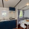 Cucina blu, tavolo apparecchiato, divano a righe blu.