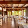 Interno di un ristorante con tavoli apparecchiati e grandi finestre.