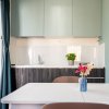 Cucina moderna con tavolo e fiori in vaso.