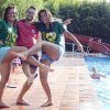 Due ragazze e un ragazzo sorridenti vicino a una piscina.
