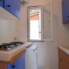 Piccola cucina con piano cottura e pensili blu.