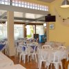 Ristorante con tavoli apparecchiati, sedie bianche, tovaglie bianche e blu.
