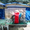 Tenda da campeggio con tavolo, sedie e biciclette davanti.