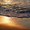 Onde che si infrangono su una spiaggia al tramonto.
