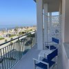 Balcone con sedie blu e vista sul mare.