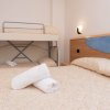 Stanza con letto matrimoniale, letto a castello e asciugamani piegati.