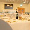 Tavola apparecchiata con bicchieri di vino, pane e bottiglie in un ristorante elegante.