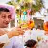 Un brindisi con bicchieri di cocktail variopinti tra quattro persone.