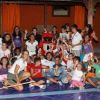 Gruppo di bambini e adulti in festa con un costume rosso.