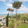 Giardino con alberi, vista mare sullo sfondo.