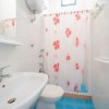 Bagno con doccia, lavabo e WC bianchi.