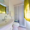 Bagno con tenda verde, lavabo e doccia.
