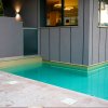 Piscina adiacente a un edificio moderno con finestre.