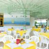 Sala ristorante con tovaglie gialle e sedie bianche.