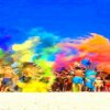 Gruppo di persone lancia polveri colorate su una spiaggia.
