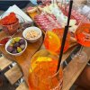 Aperitivi spritz e tagliere di salumi su un tavolo.