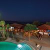Piscina illuminata di notte, con luna sullo sfondo.