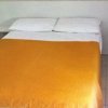 Letto matrimoniale con copriletto arancione.