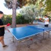 Due persone giocano a ping pong all'aperto.