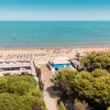 Spiaggia sabbiosa con ombrelloni e lettini.