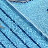 Una piscina con corsie in evidenza, una persona nuota nell'acqua trasparente.