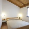 Camera da letto con letto matrimoniale, due comodini e luci accese.
