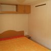 Camera con letto matrimoniale, copriletto arancione, armadio a muro.