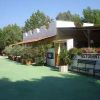 Un ristorante con terrazza, piante e fiori all'esterno sotto un cielo sereno.