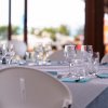 Tavola apparecchiata con bicchieri e tovaglioli azzurri in un ristorante all'aperto.