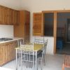Cucina con mobili in legno e tavolo.