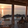 Tramonto visto da una terrazza sul mare, due persone sedute.