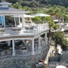 Terrazza con tavoli bianchi e vista mare.