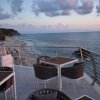 Tavoli sulla terrazza con vista sulla spiaggia e sull'oceano al tramonto.