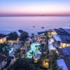 Resort costiero al tramonto con piscina.