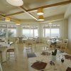 Una sala da pranzo con tavoli apparecchiati vista mare.