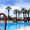 Piscina con palme sotto un cielo azzurro.