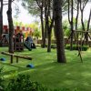 Un parco giochi con altalene e giostre su erba verde.