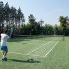 Persona che gioca a tennis su un campo all'aperto.