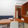 Cucina moderna con tavolo in legno e sedie bianche.