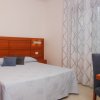 Camera da letto con letto matrimoniale e tende a motivo ondulato.
