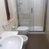 Bagno con doccia in vetro e sanitari bianchi.